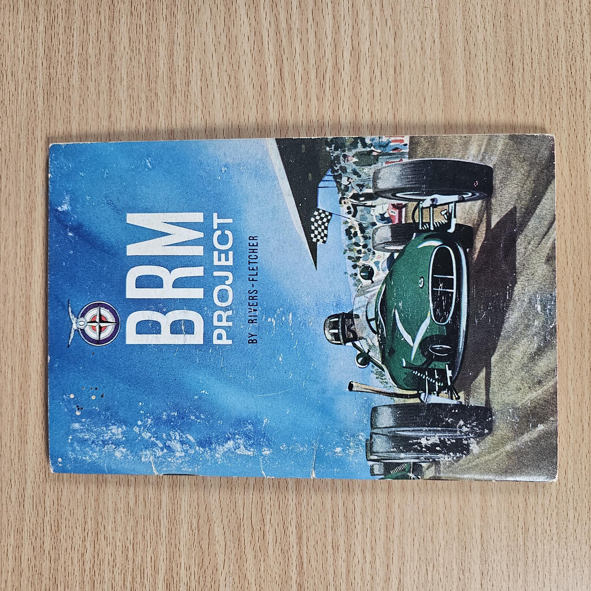 BRM Project hardcover book on wood surface; blue cover with car artwork and title