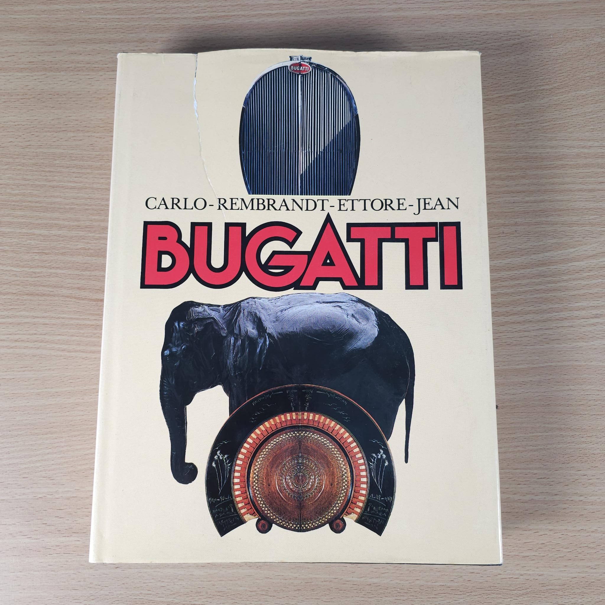 Bugatti hardcover book cover with blue oval artwork, black bull illustration, and BUGATTI logo.