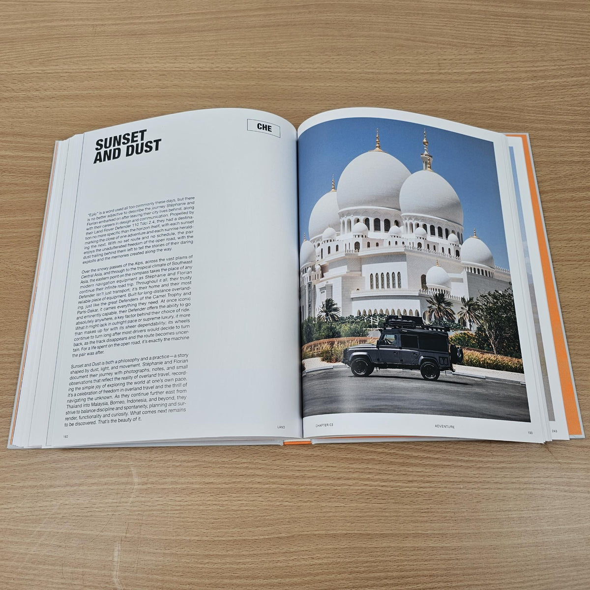 Open photo book with off-road vehicle in front of a mosque on right page