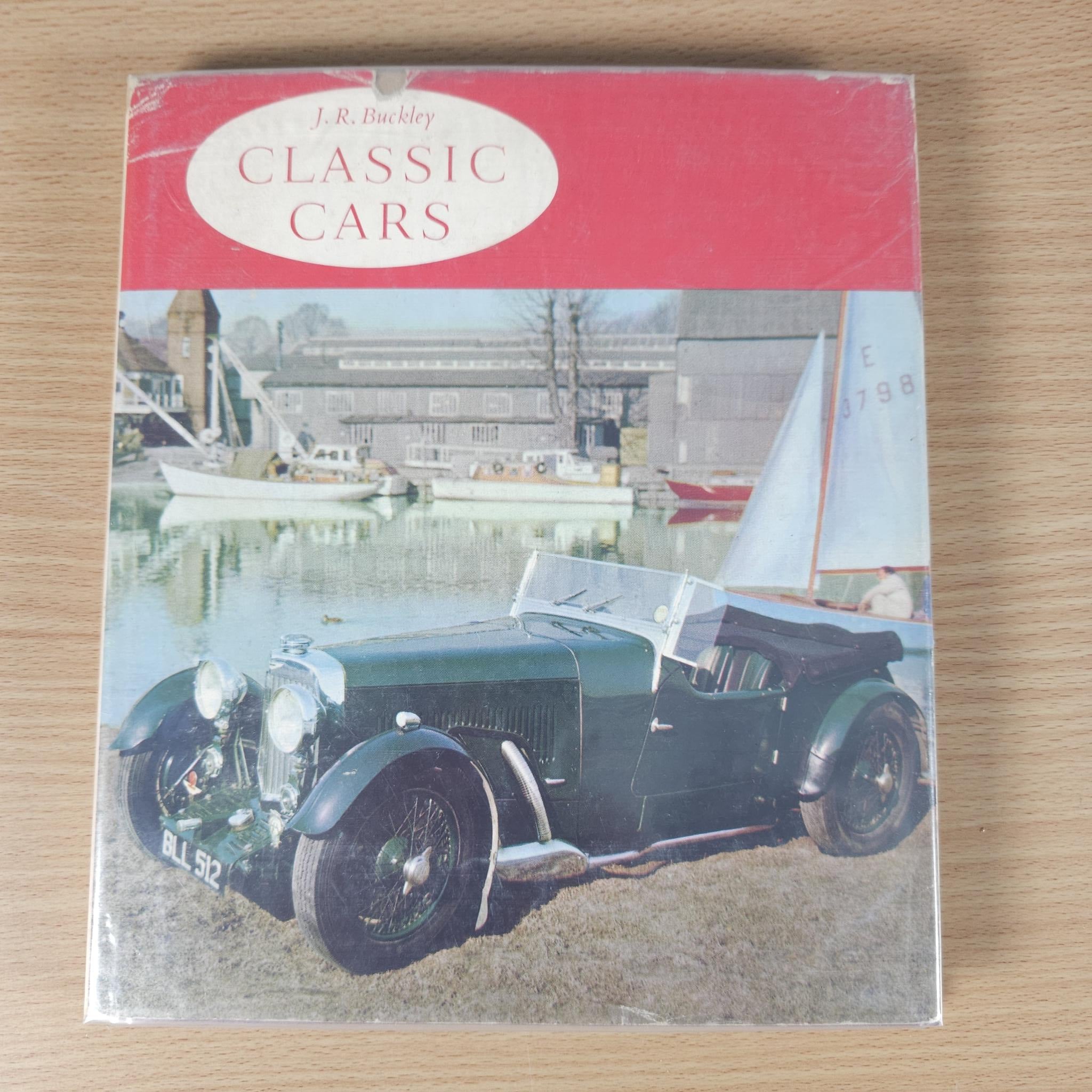 Classic car photo book cover with red top, oval title, and vintage black car photo.