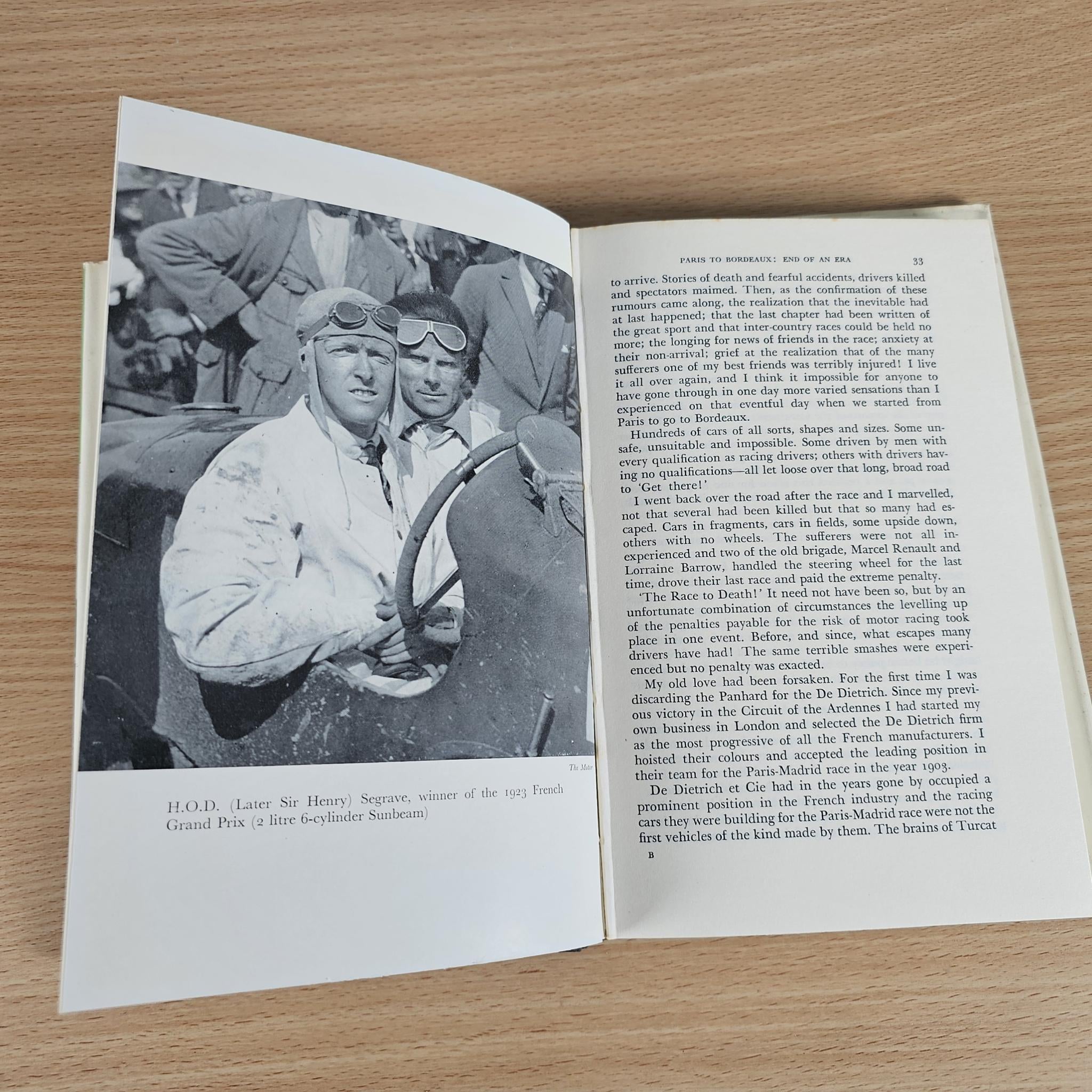 Vintage book open to a photo page with two men in racing attire