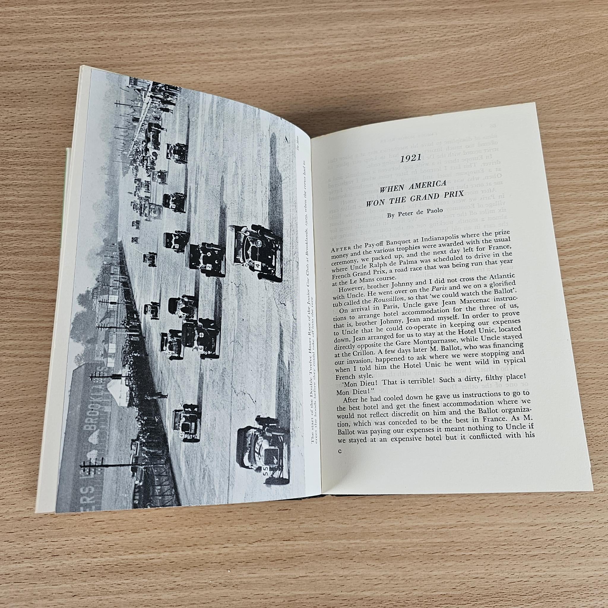 Vintage book open page with race track photo and paragraph text
