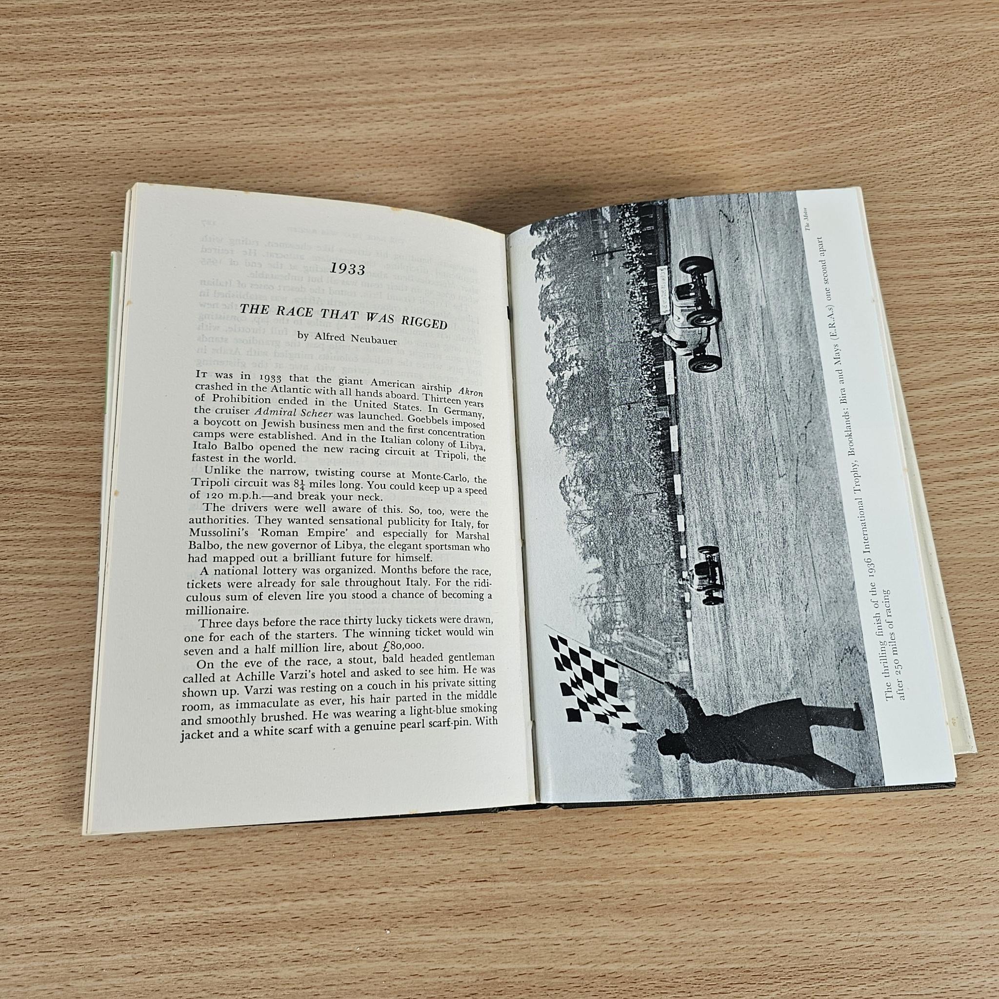 Vintage book open page with headline text and wide photo of racing cars