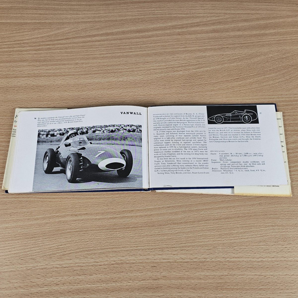 Open racing cars book with photo of vintage race car and technical text page