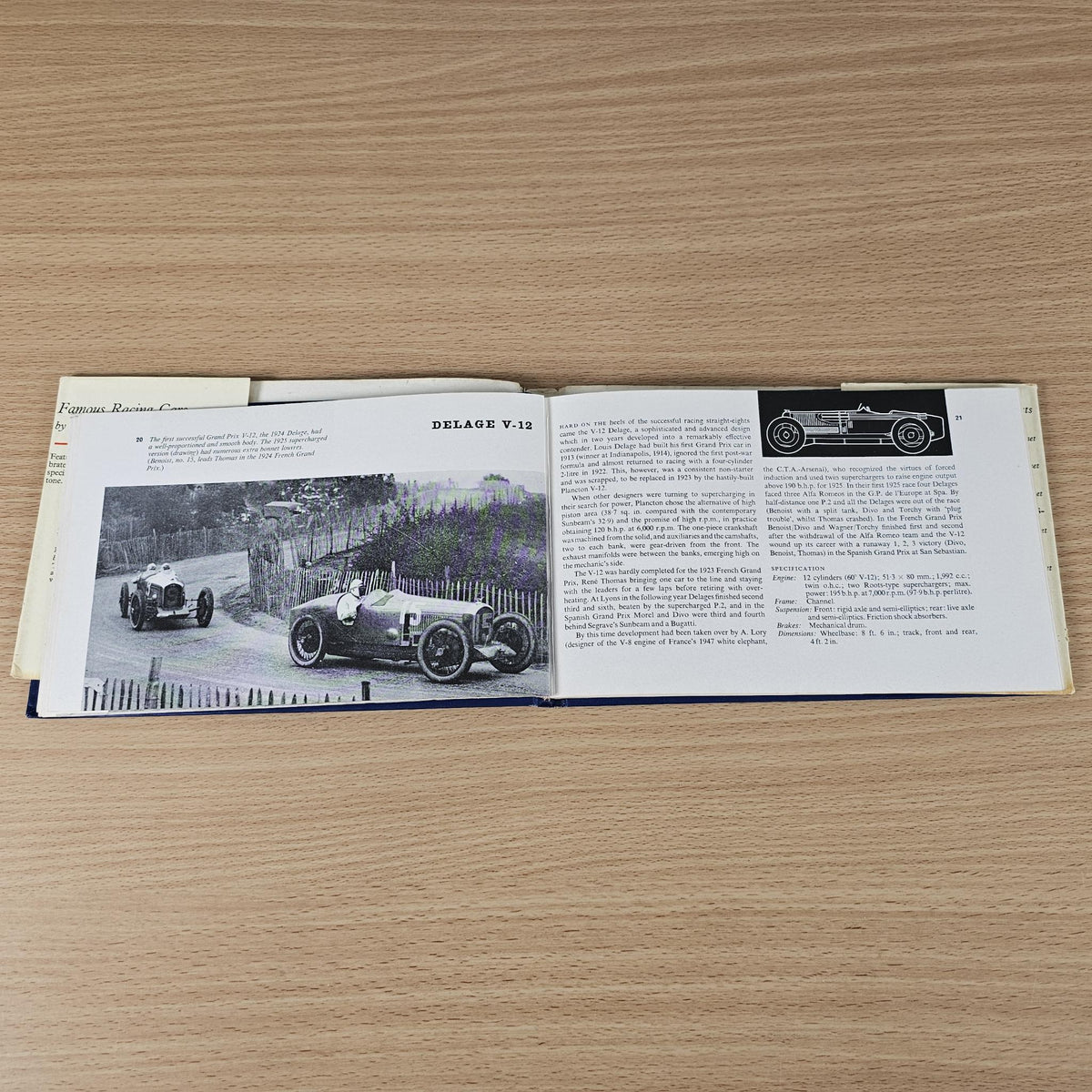 Vintage racing cars book, open spread featuring outdoor race car photo and text.