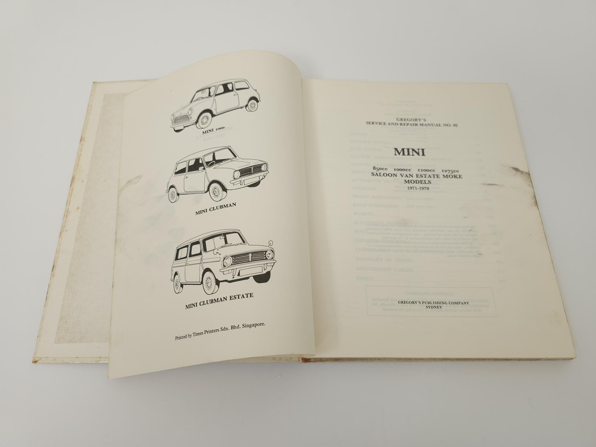 Hardcover Mini service manual open, black-and-white vehicle diagrams on pages
