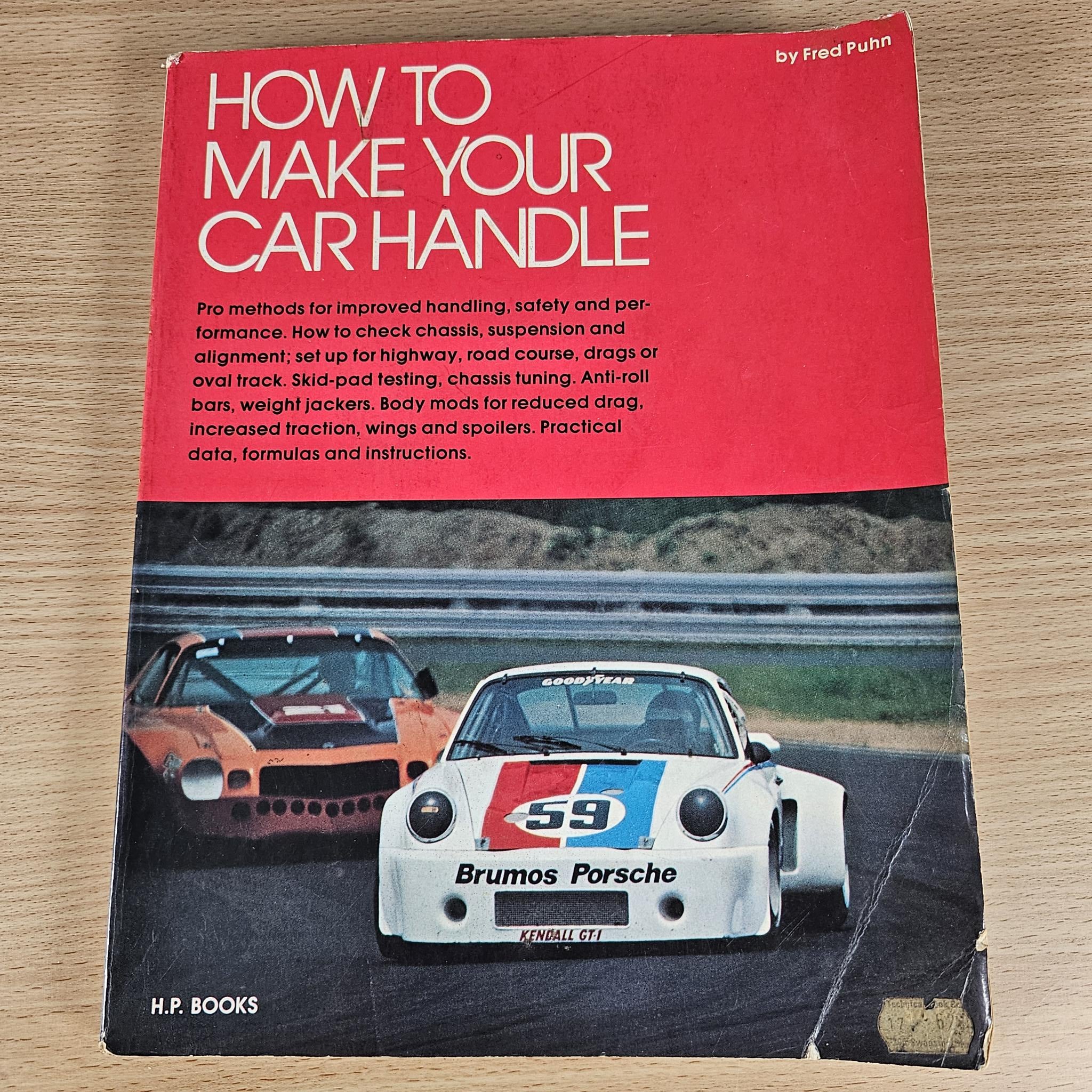 Car handling guidebook with red cover, white title, and Fred Puhn author byline