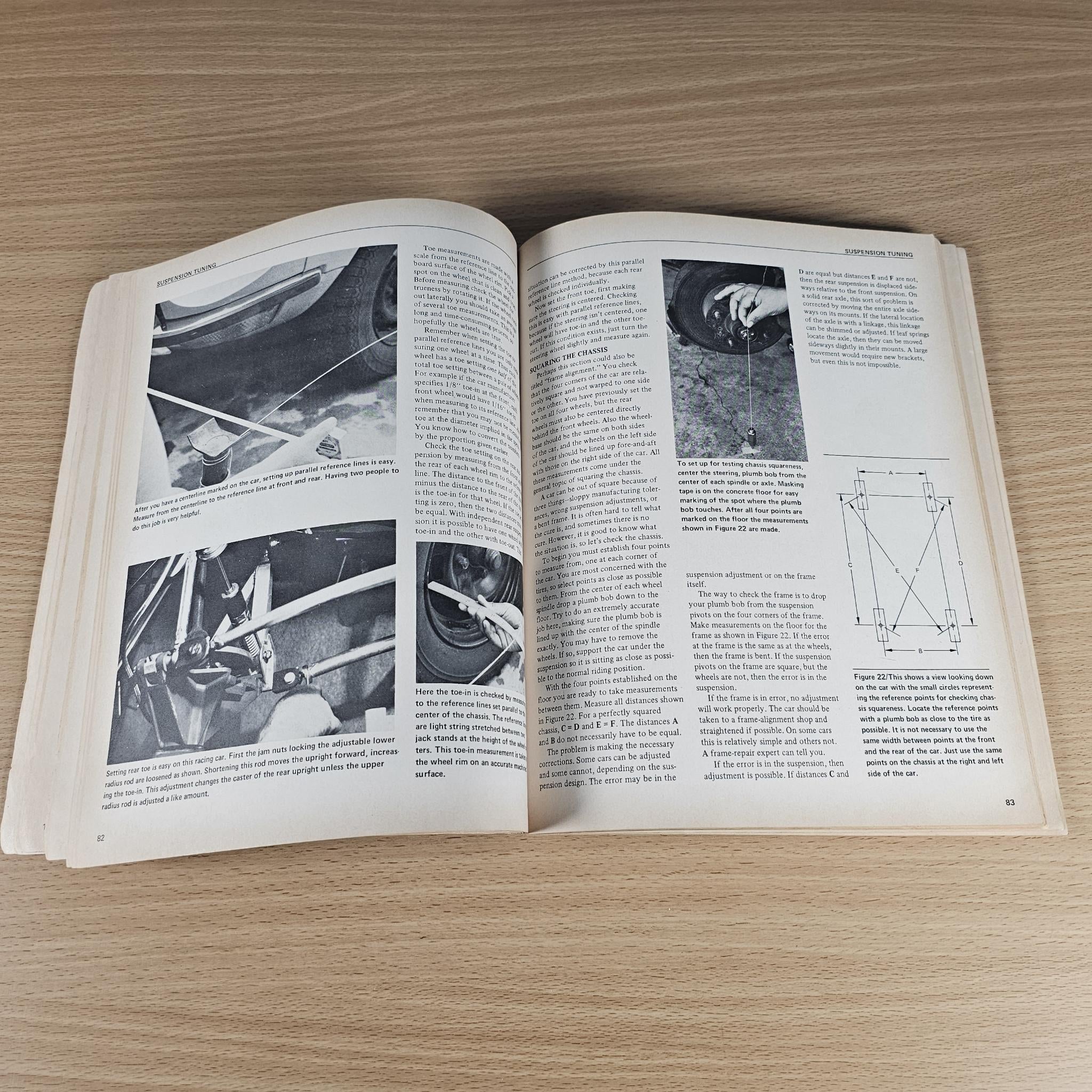 Open car handling guidebook showing grayscale vehicle photos and suspension diagrams