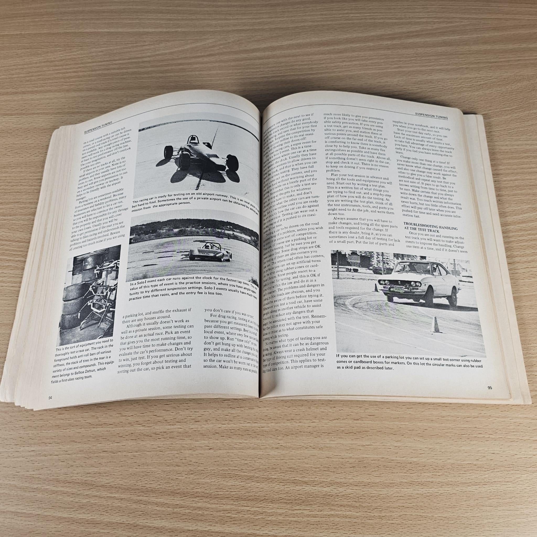Open car handling guidebook featuring grayscale vehicle photos and dense reference text