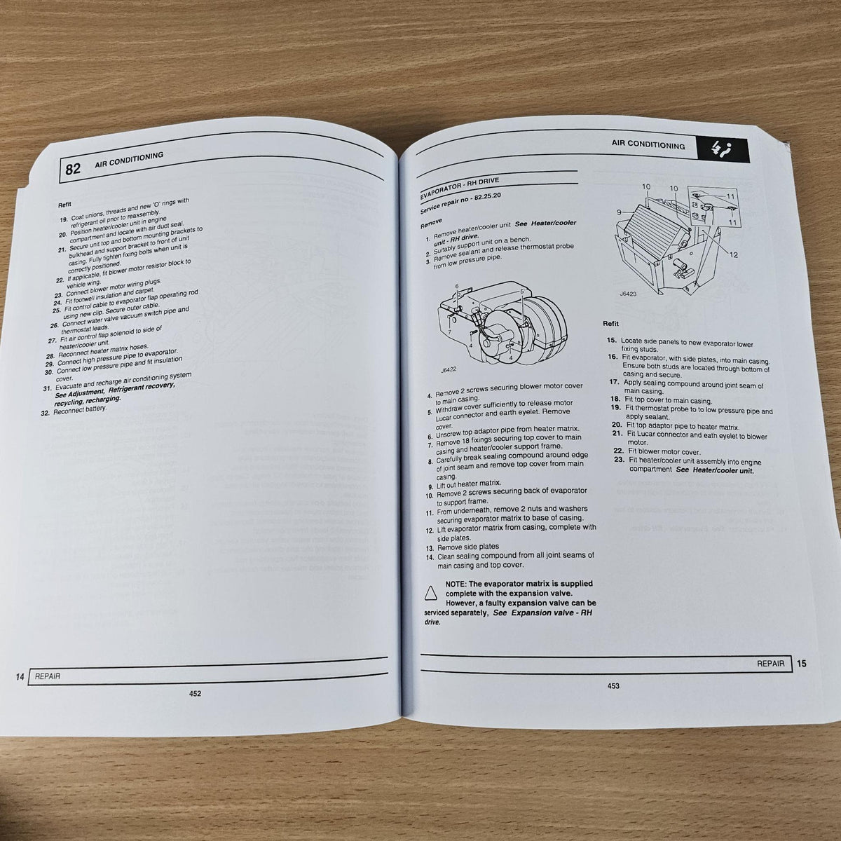 Workshop manual open to air conditioning repair pages with diagrams and numbered steps