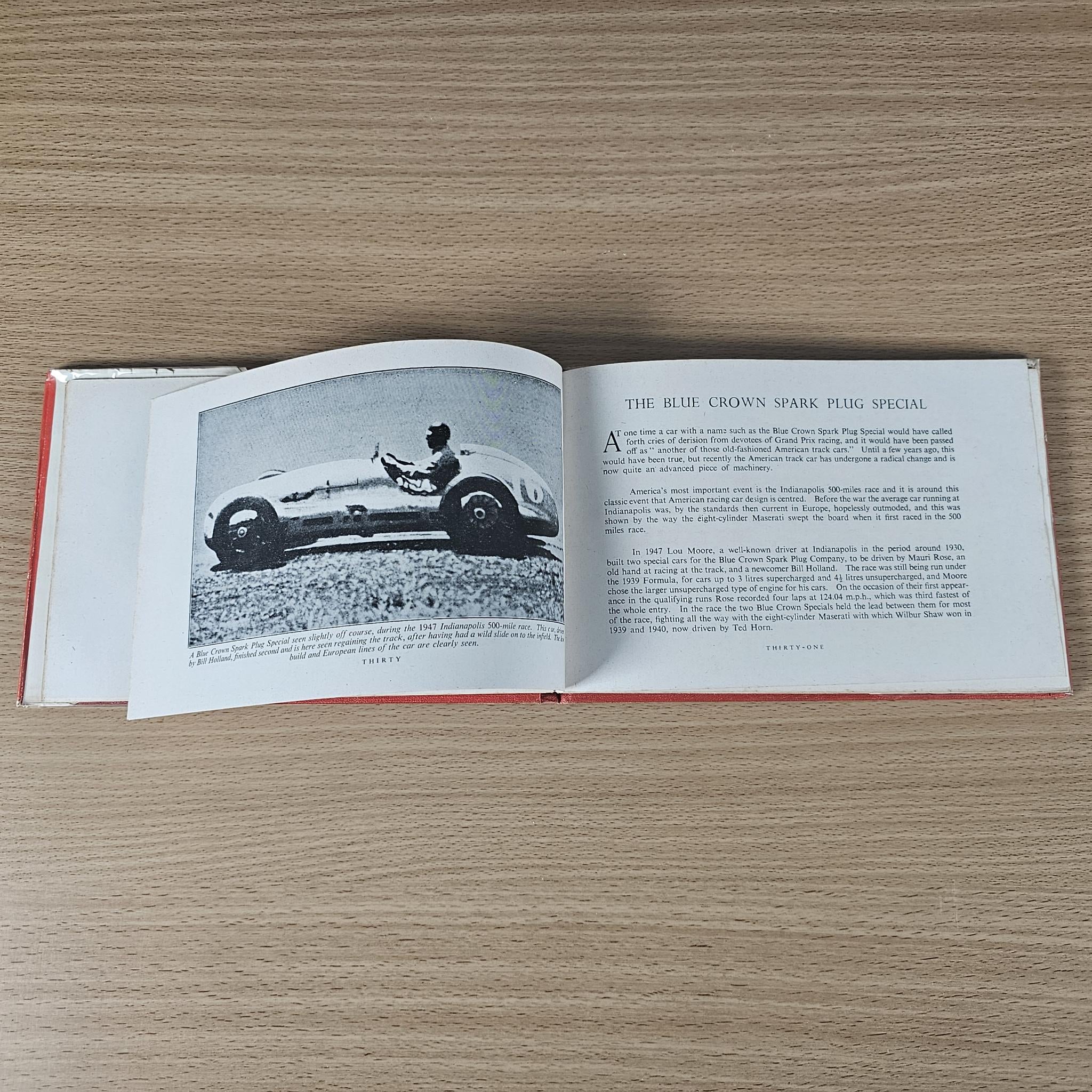 Open vintage book showing a race car photo on left and a titled article on right.