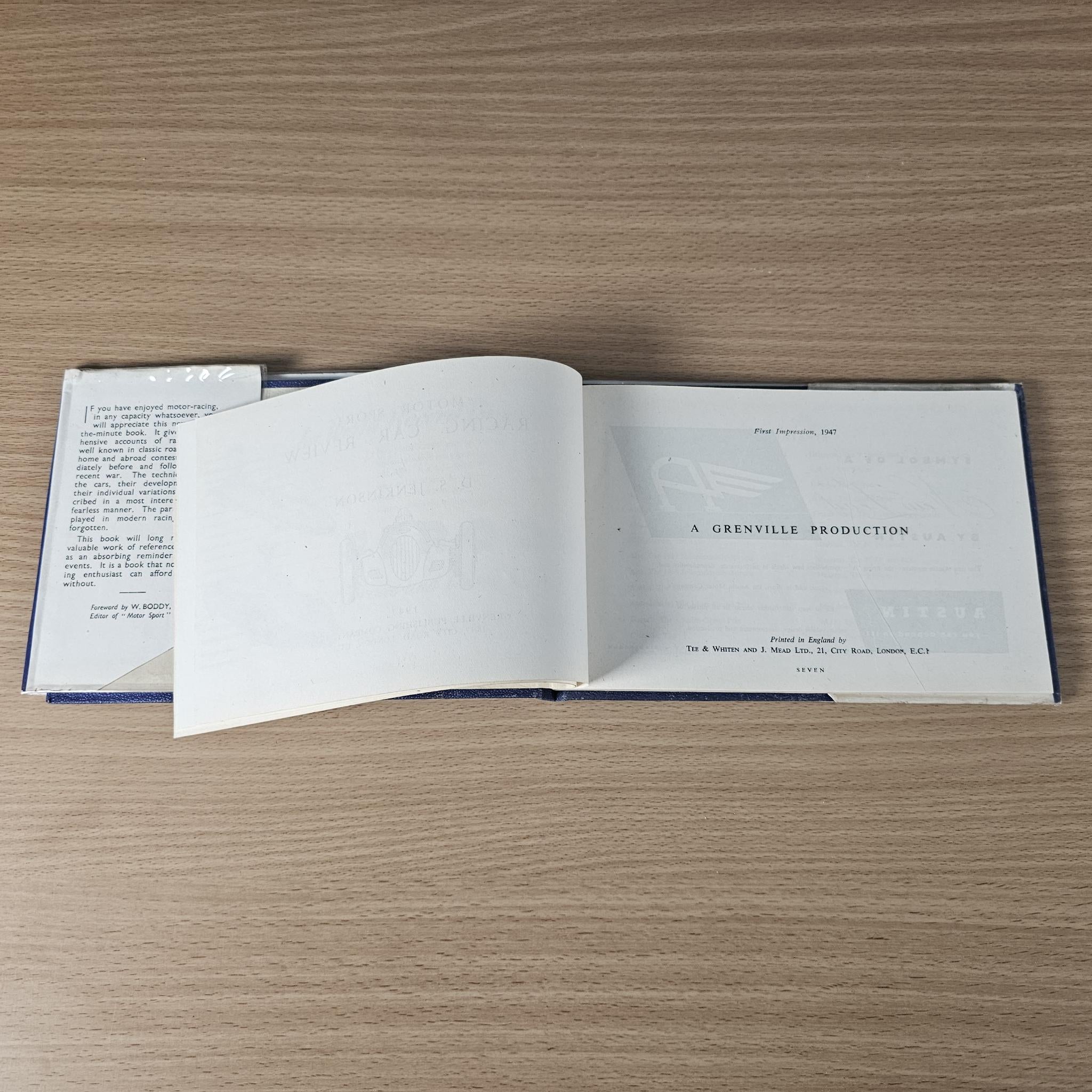 Racing car review book open to a production credits page with centered text