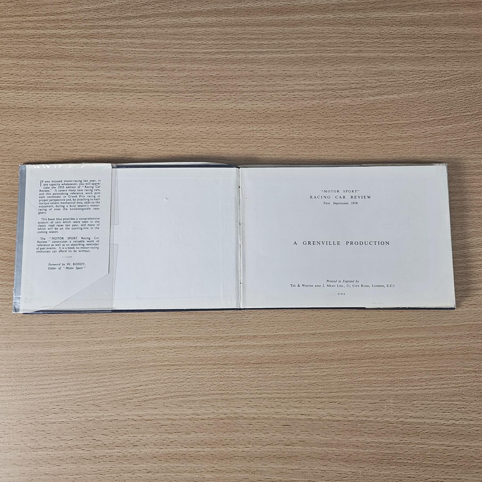 Open vintage racing car review book showing title and production information pages