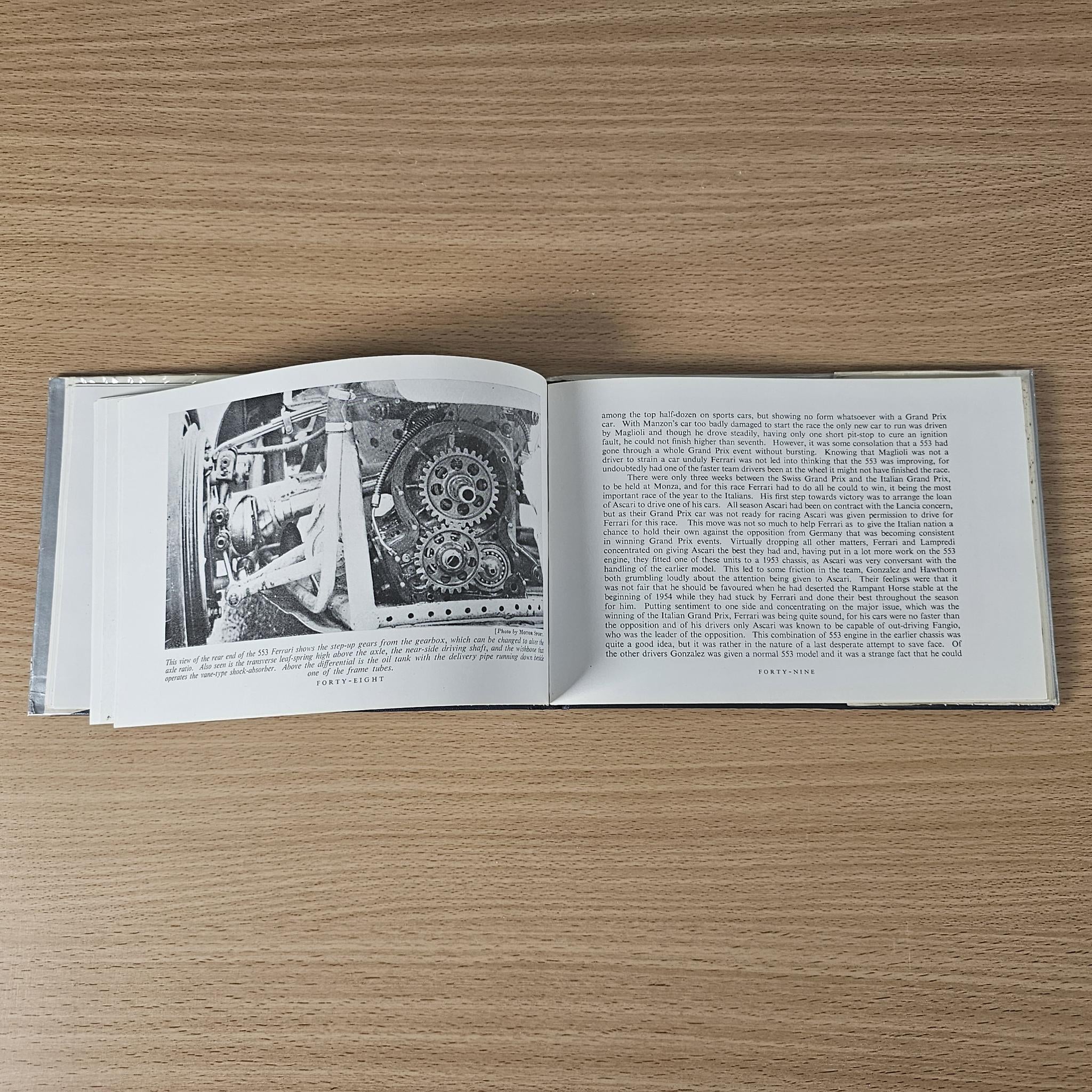 Open vintage racing car review book with black-and-white photos and printed text