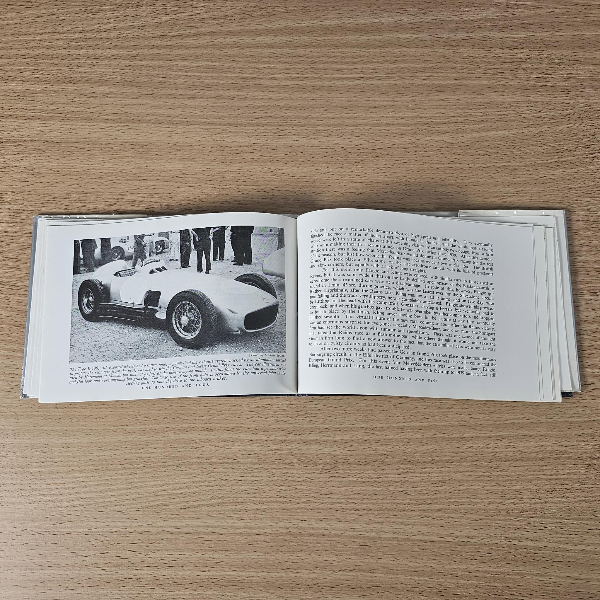 Open vintage racing car review book with race car photo and dense text page