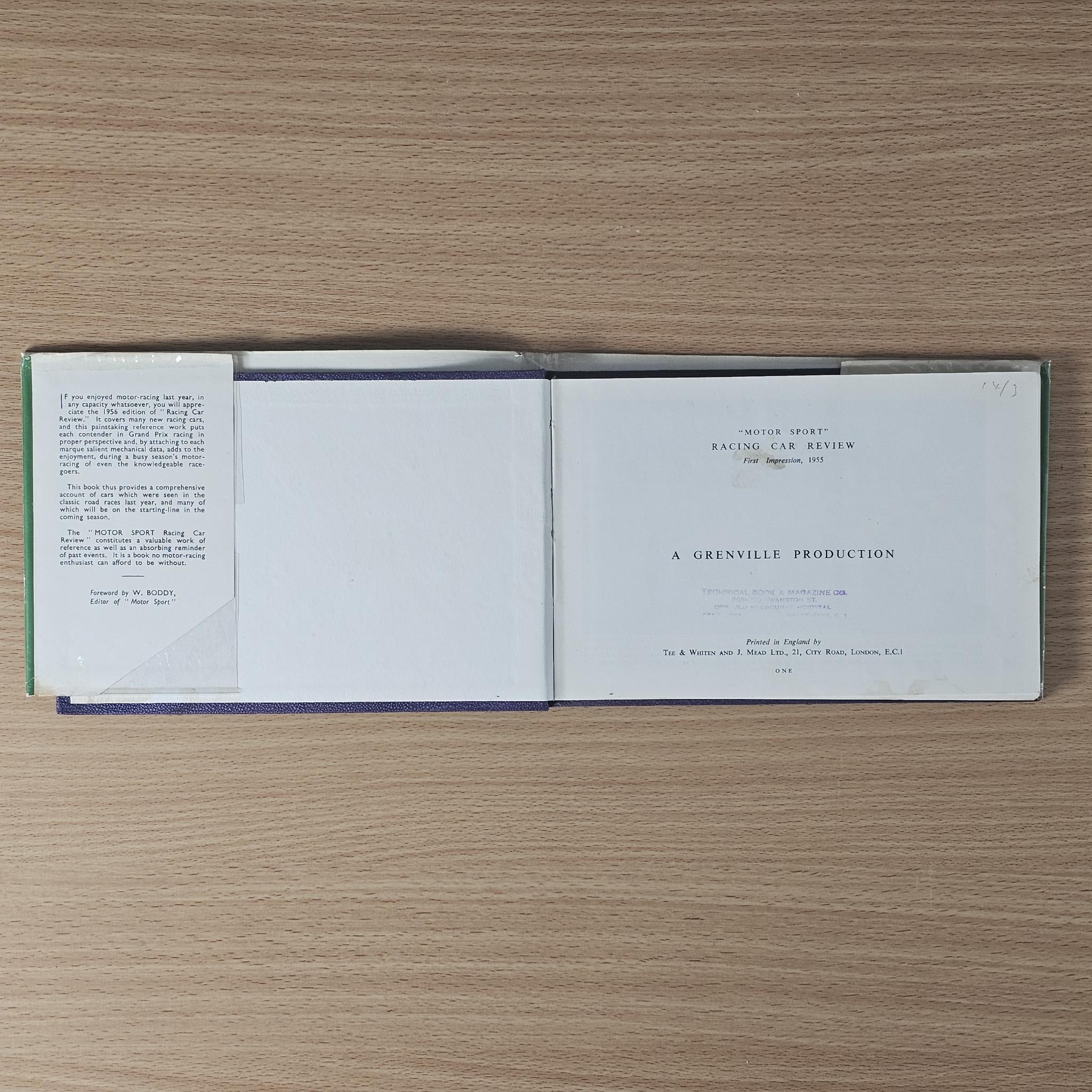 Vintage racing car review book, open with white interior pages and small printed text