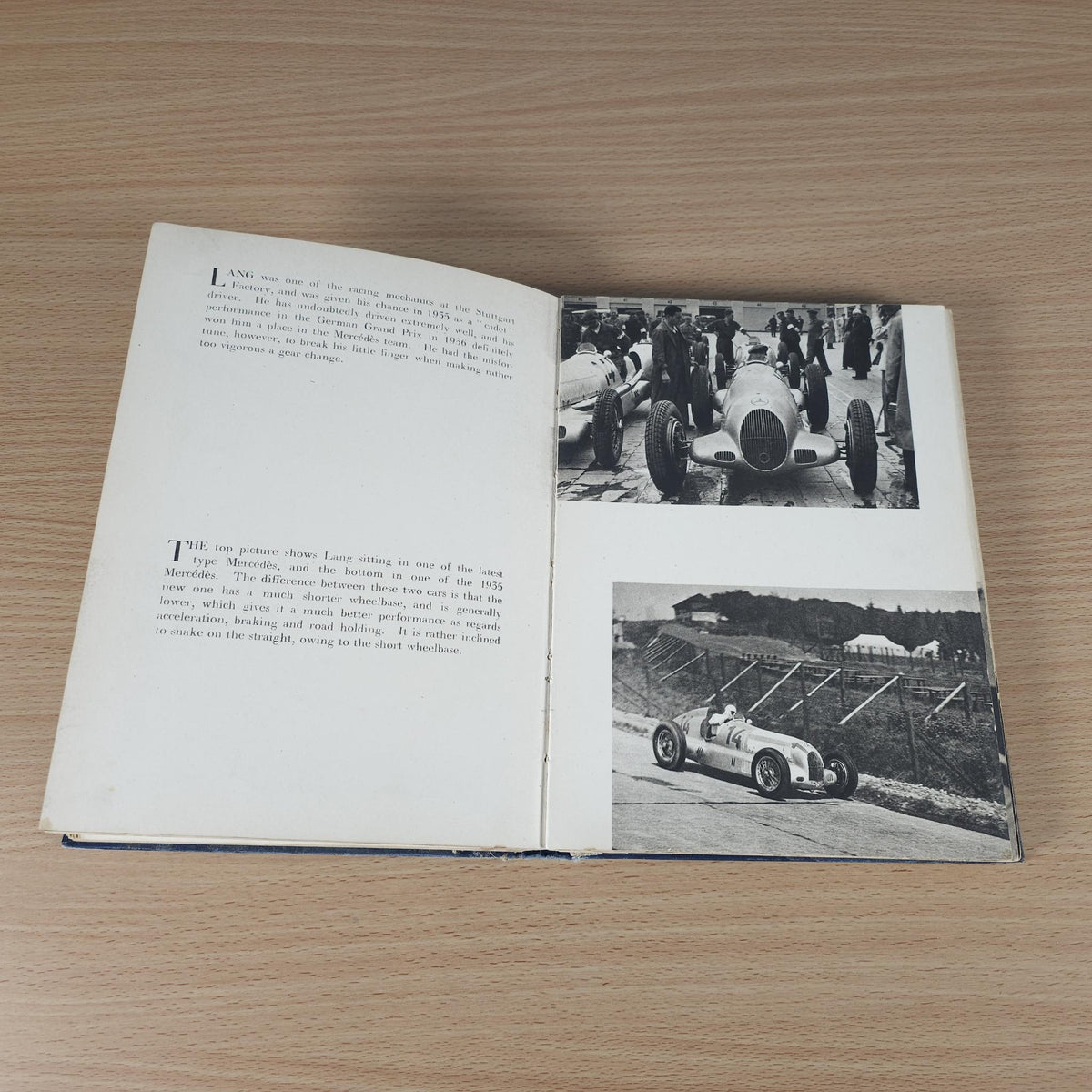 Vintage racing book open, featuring printed text and black-and-white race car photos
