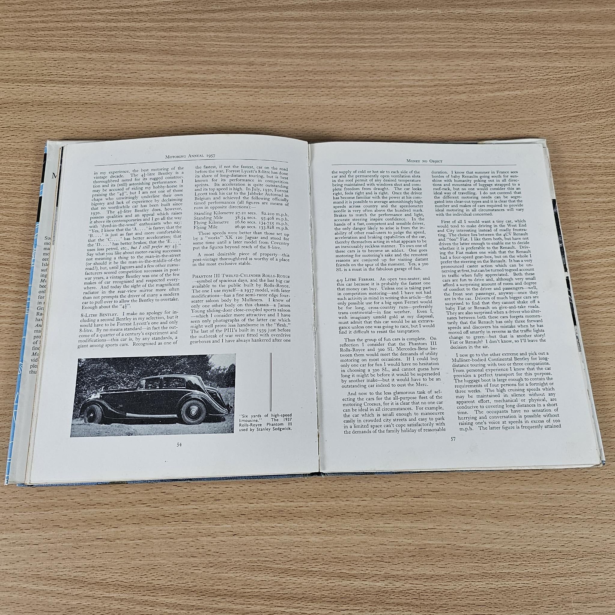Open book with printed text and small vintage car photo on left page