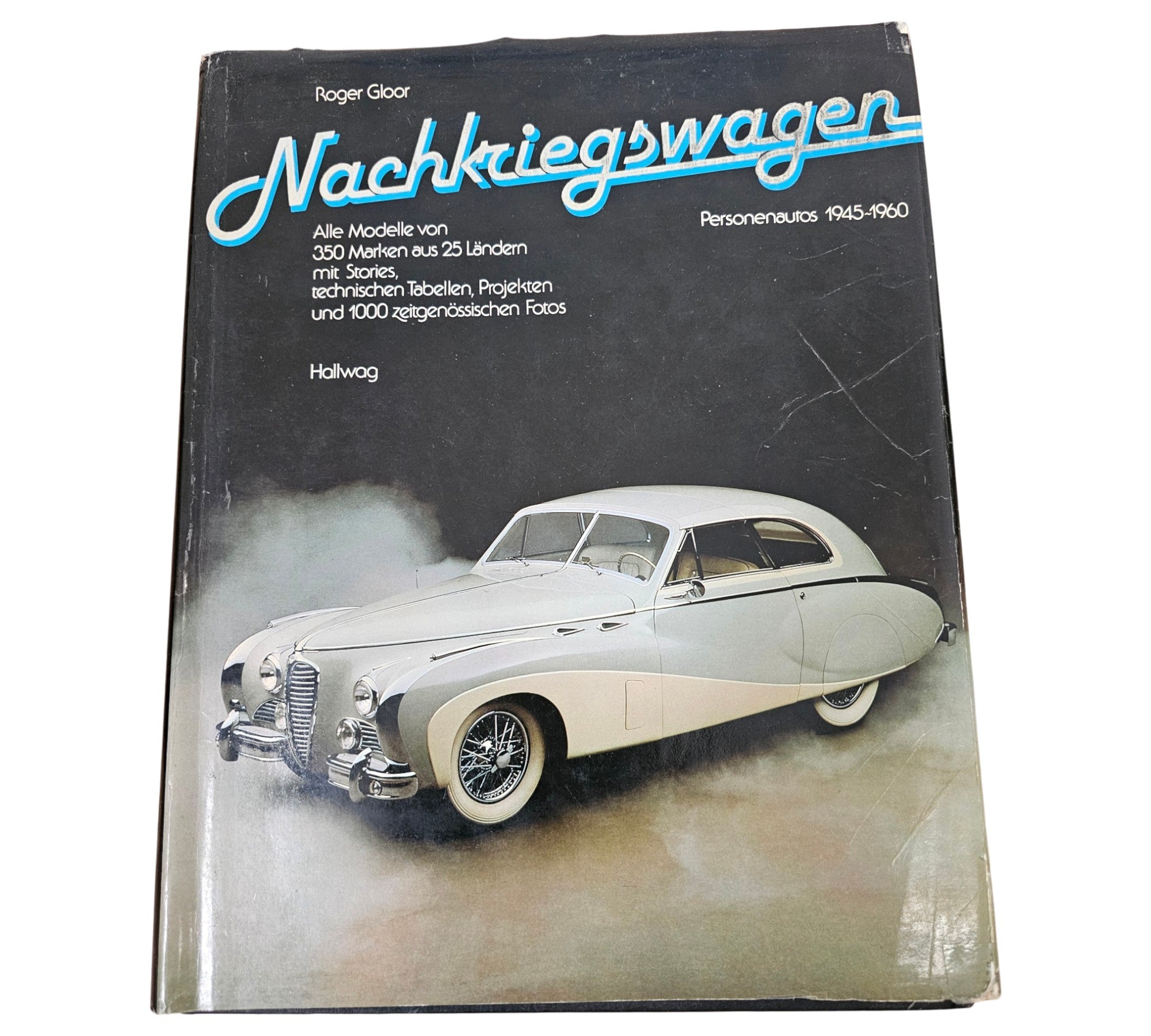 Vintage automotive book page, front view of a gray classic car on the cover