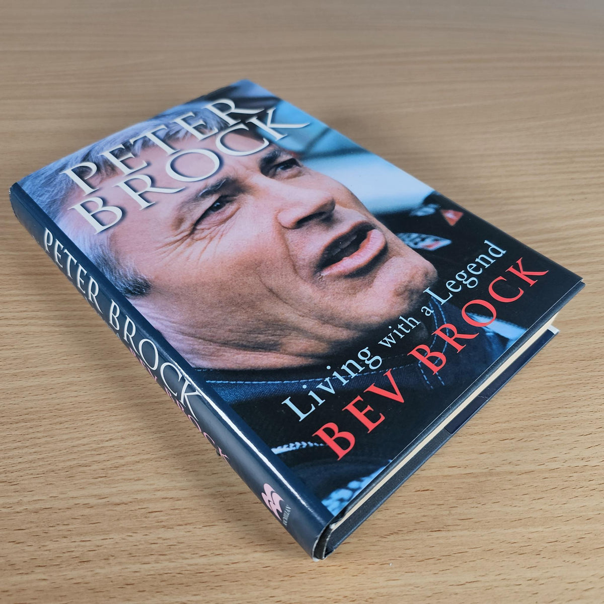Hardcover racing biography book with Peter Brock portrait on blue cover