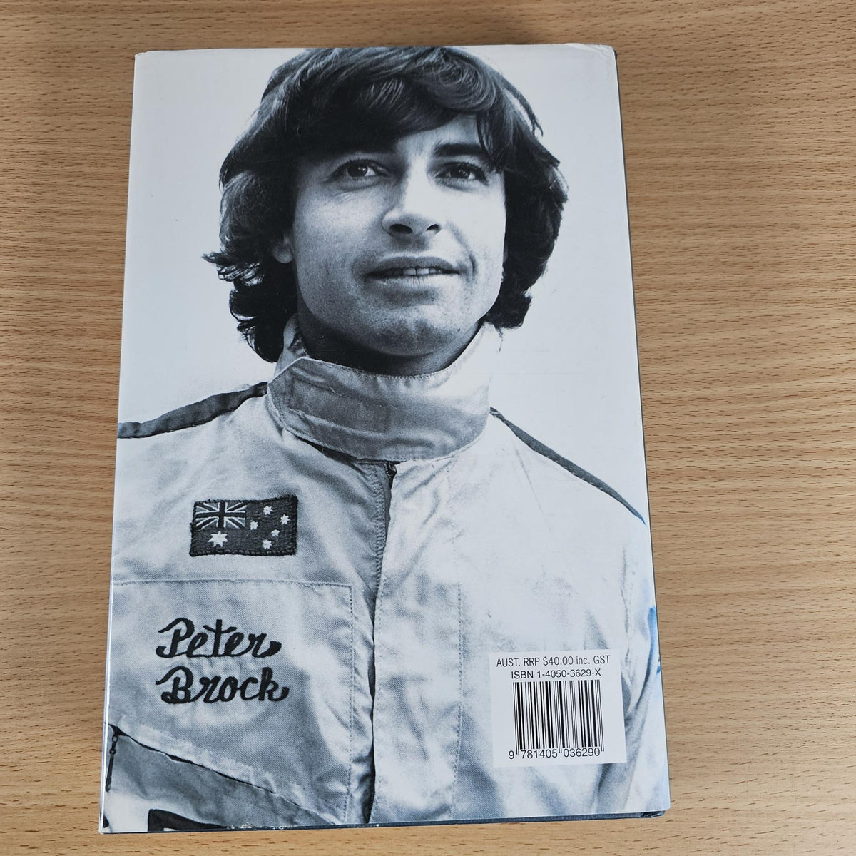 Hardcover book cover with Peter Brock portrait in a light racing jacket