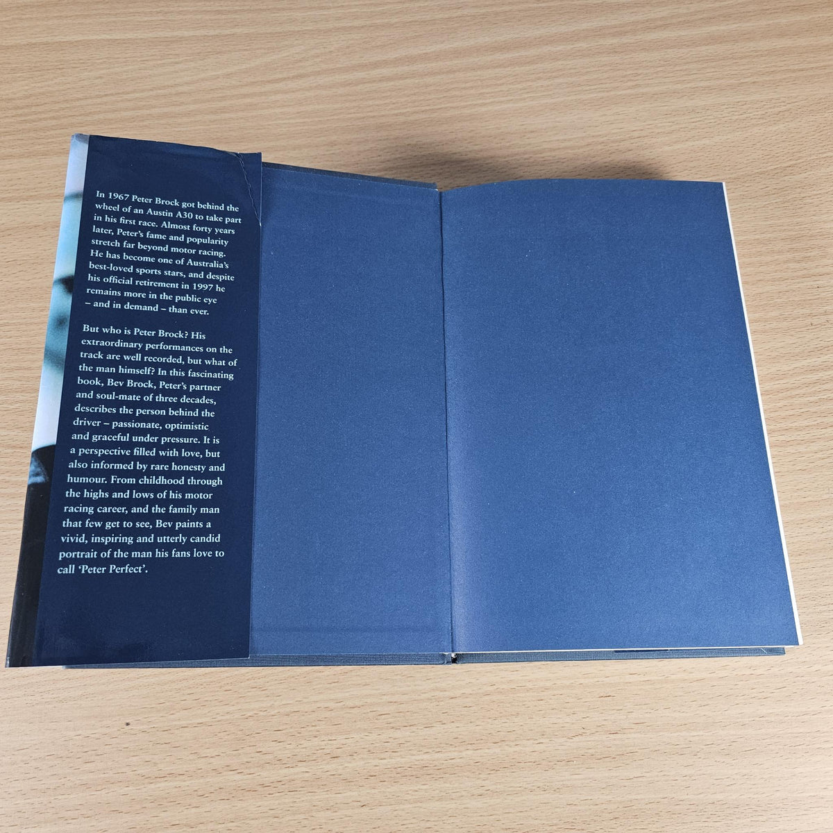 Open book with blue page spreads and small printed text on the left page