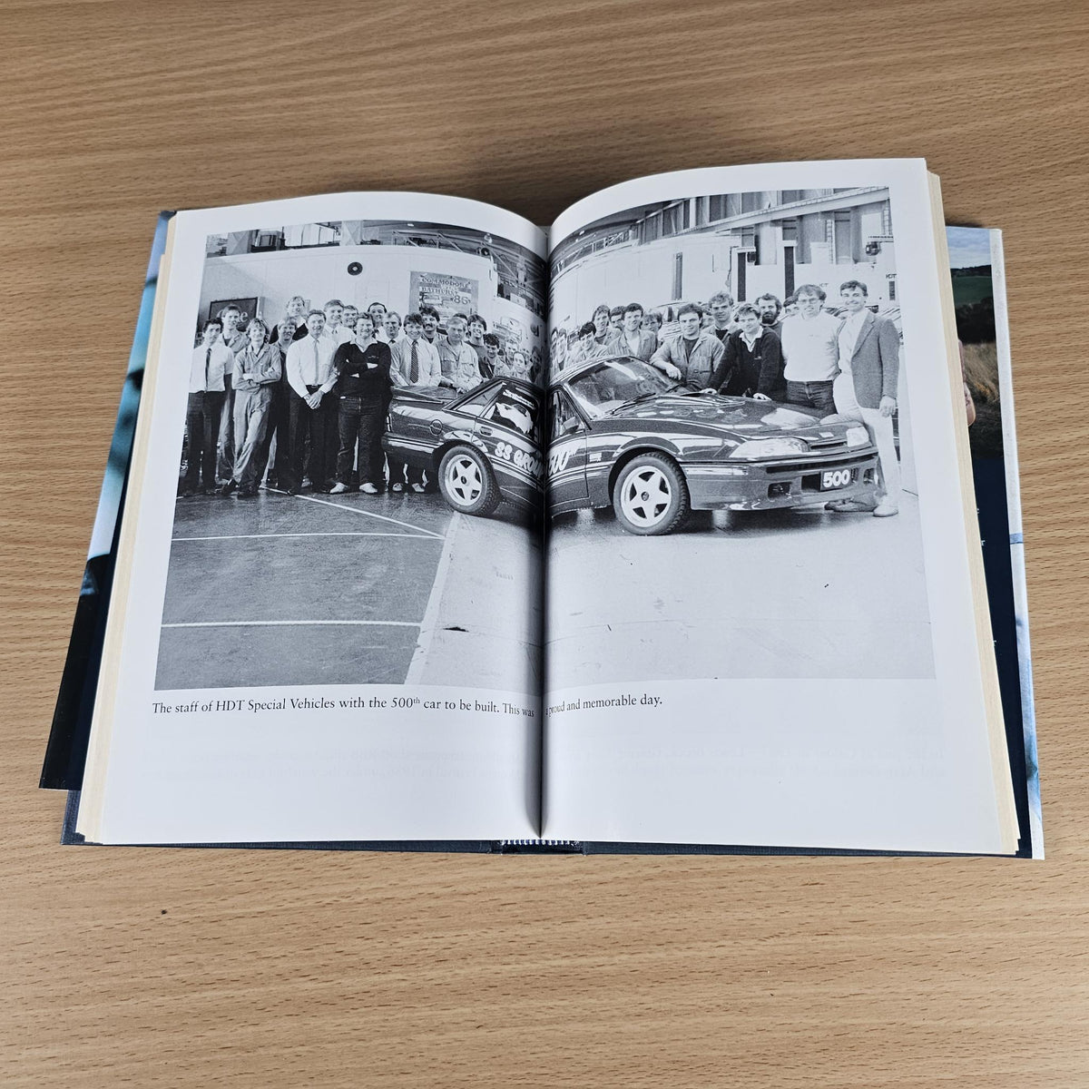 Open book spread featuring a black-and-white photo of a car and group