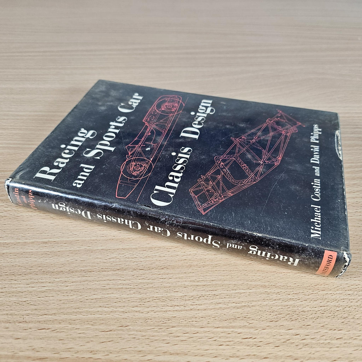 Hardcover automotive engineering book with dark cover and chassis design illustration