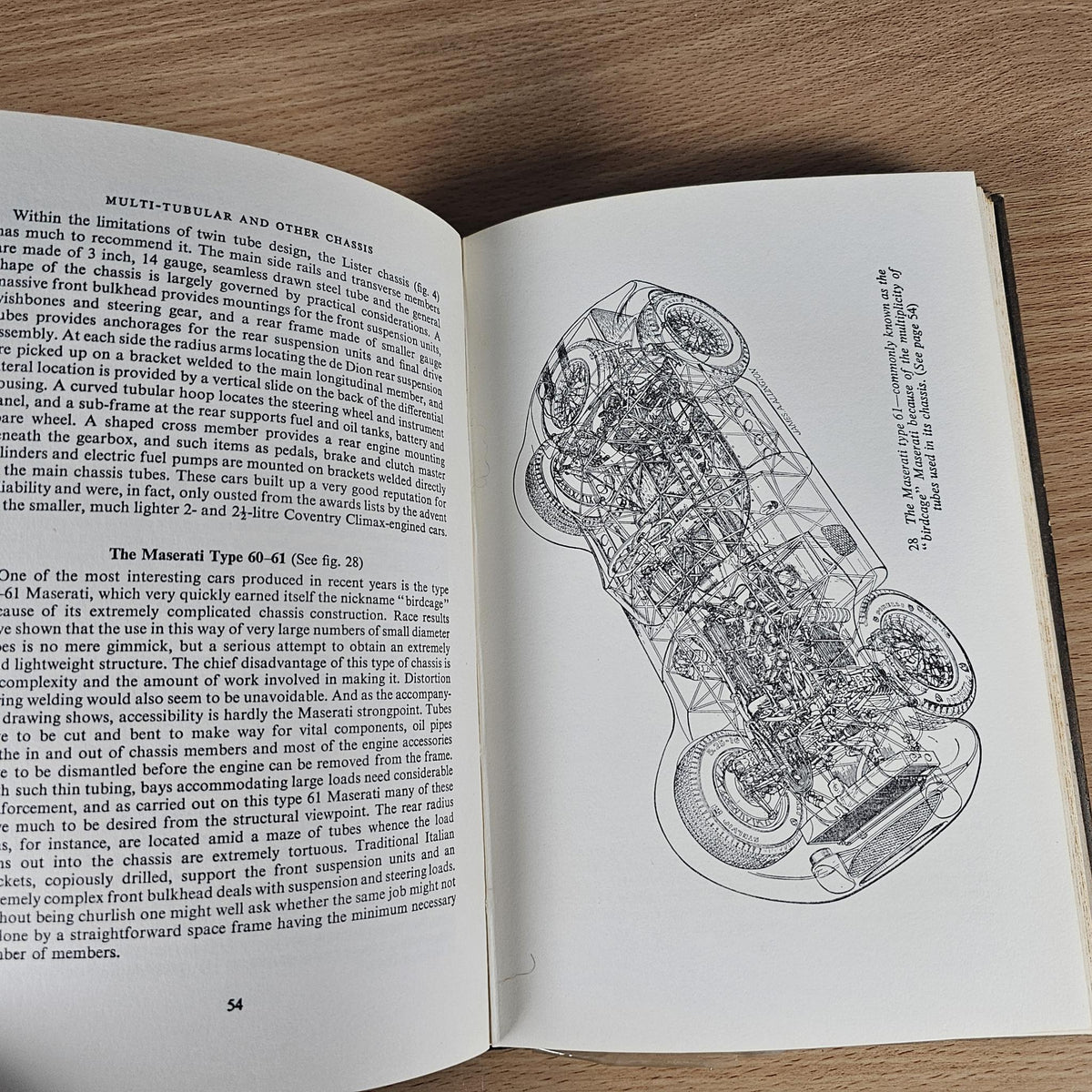 Open hardcover book with line drawing of a chassis and labeled parts
