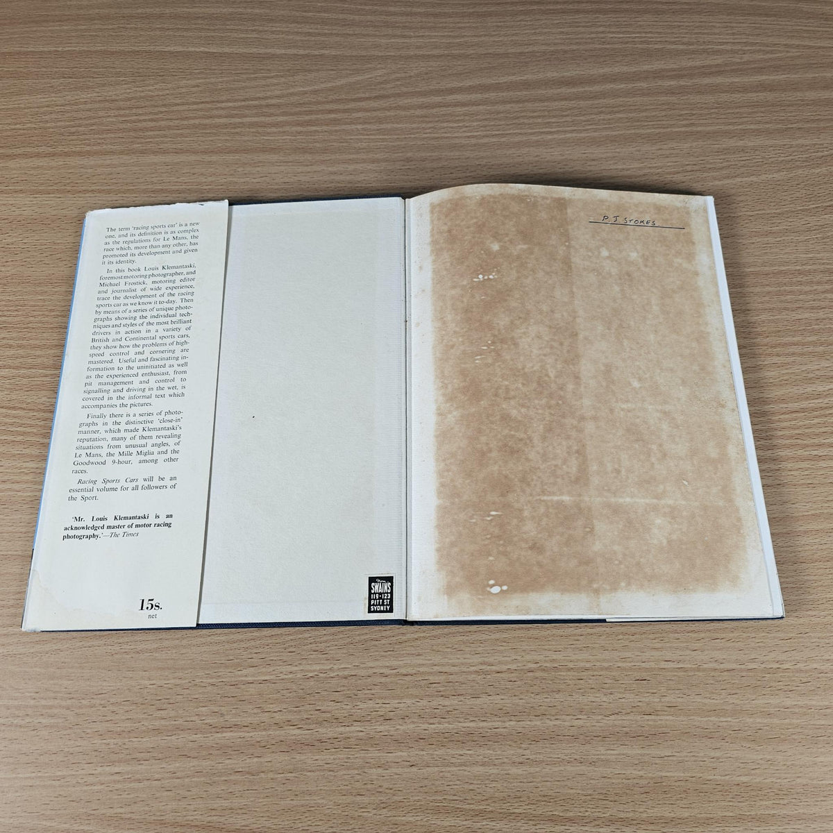 Vintage hardcover motorsport book, open with text pages and worn tan back cover