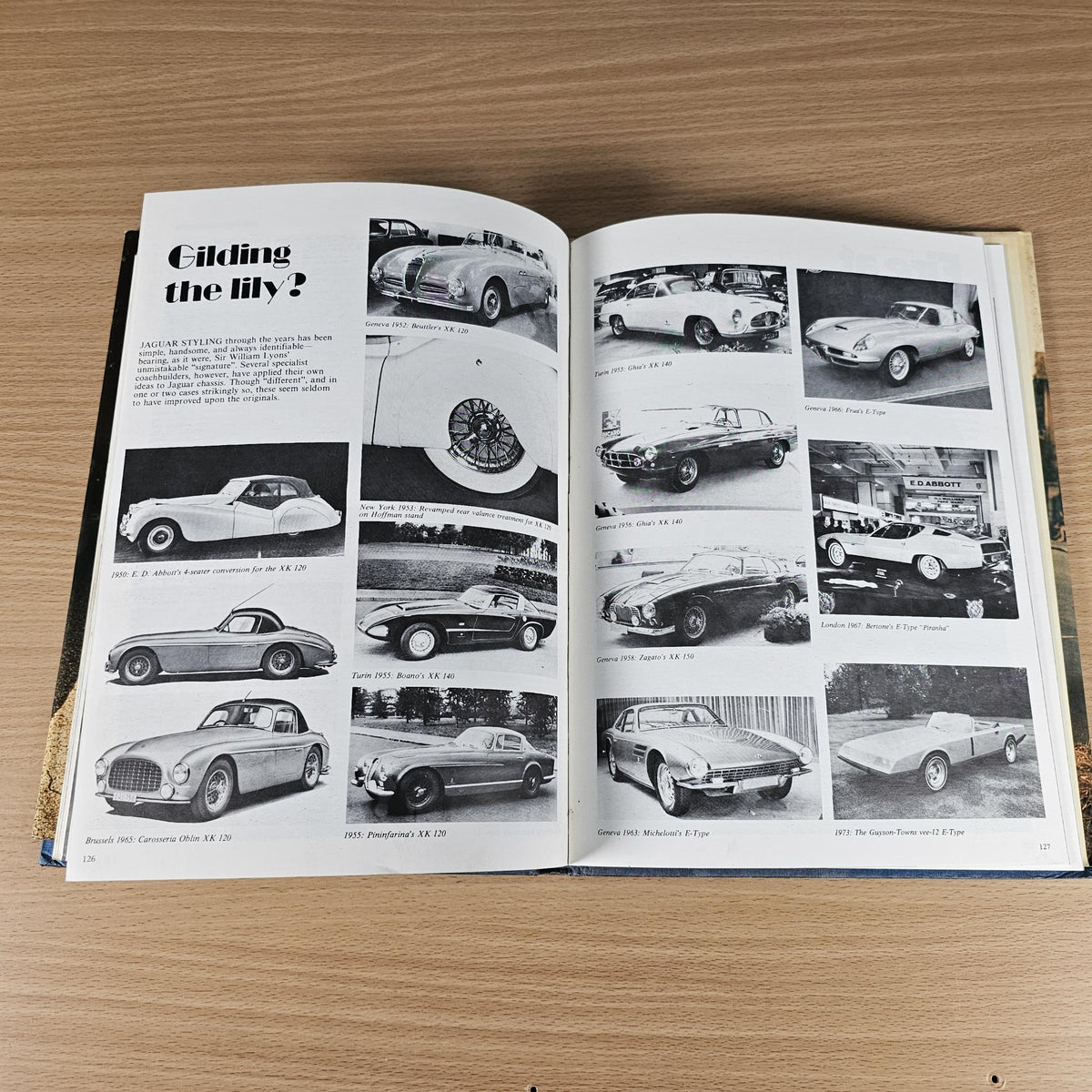 Open Jaguar sports book with black-and-white car photo spread