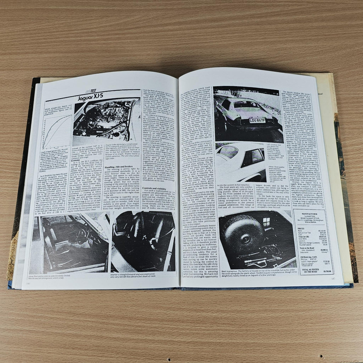 Open Jaguar sports book with XJS engine bay photos and article text