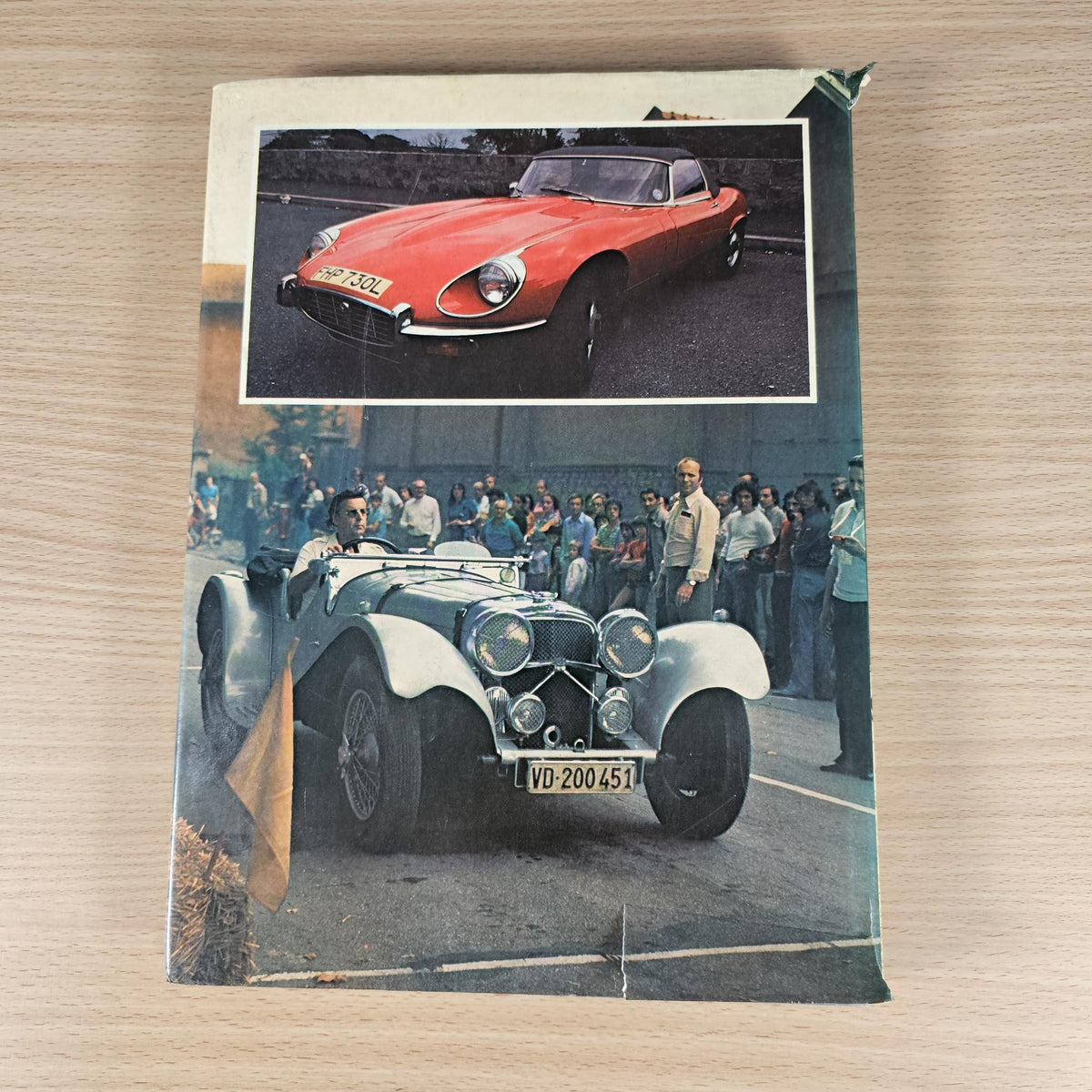 Vintage car book page with red Jaguar photo above black-and-white crowd and cars