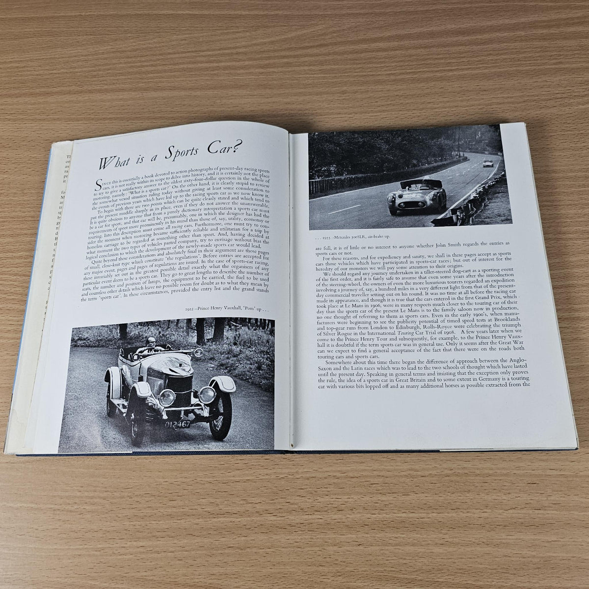 Open vintage racing sports cars book page spread with car photos and printed text