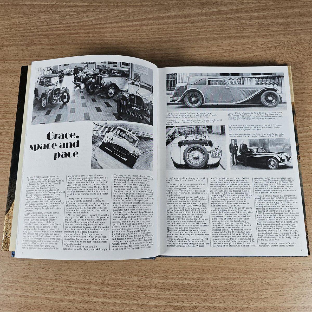 Open vintage car book spread with black-and-white car photos and paragraph text columns