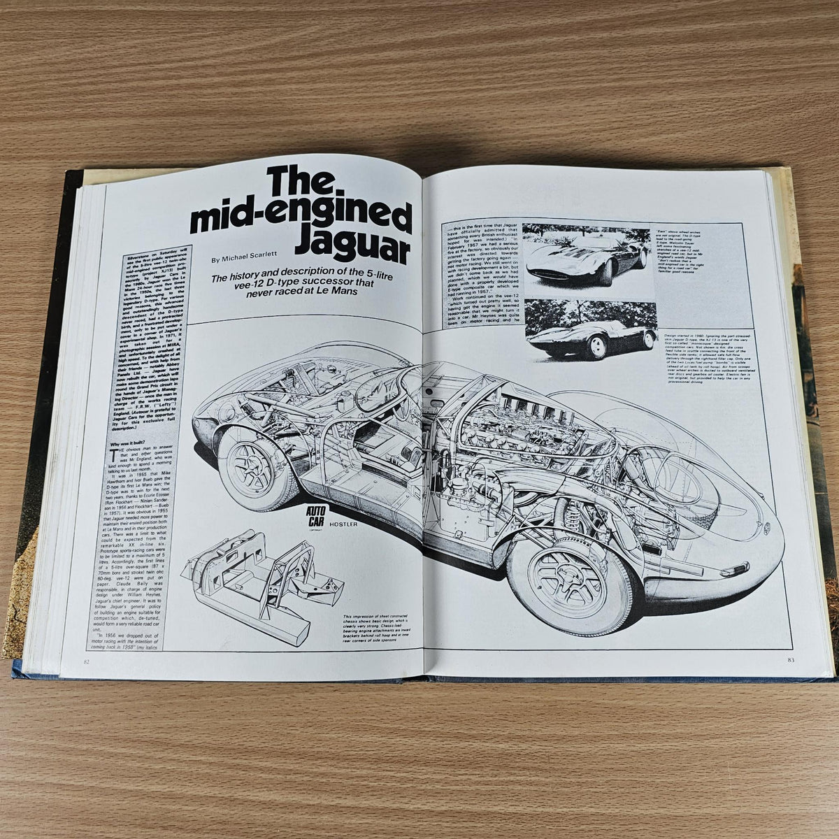Open vintage car book spread with mid-engined Jaguar cutaway illustration and photos