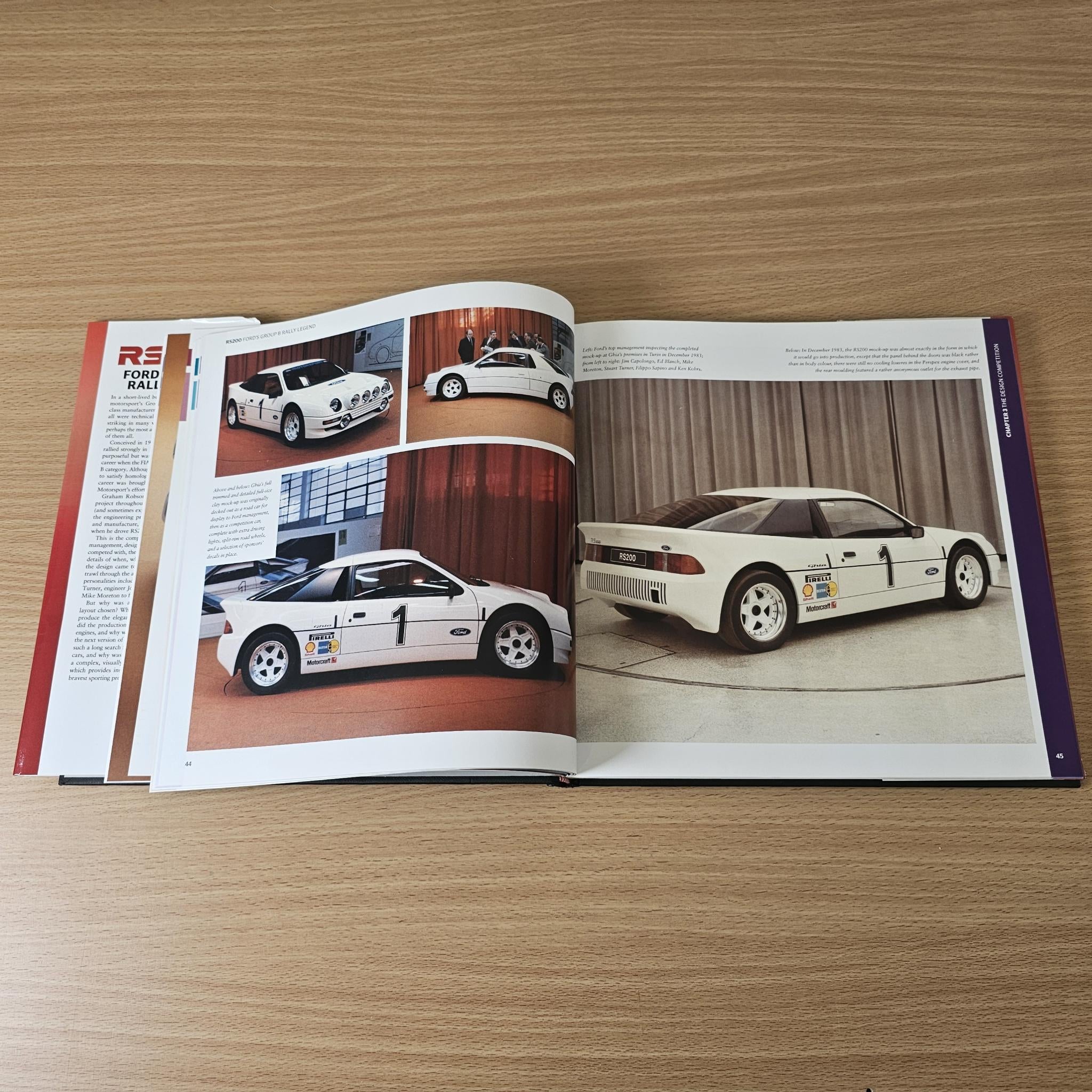 Open rally book showing two-page car photo layouts with captions and paragraph text.