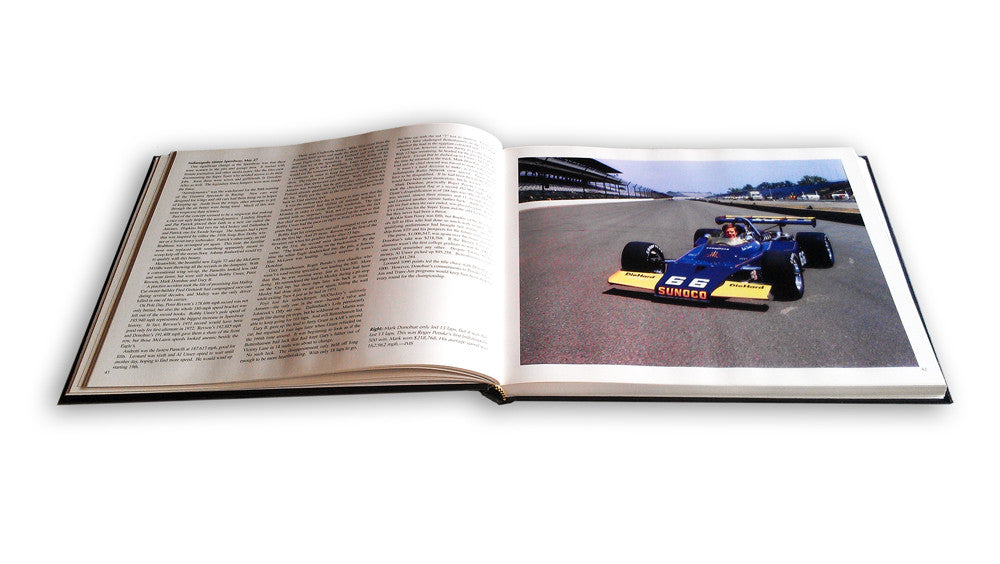 Open racing book with full-page photo of a blue race car and surrounding text