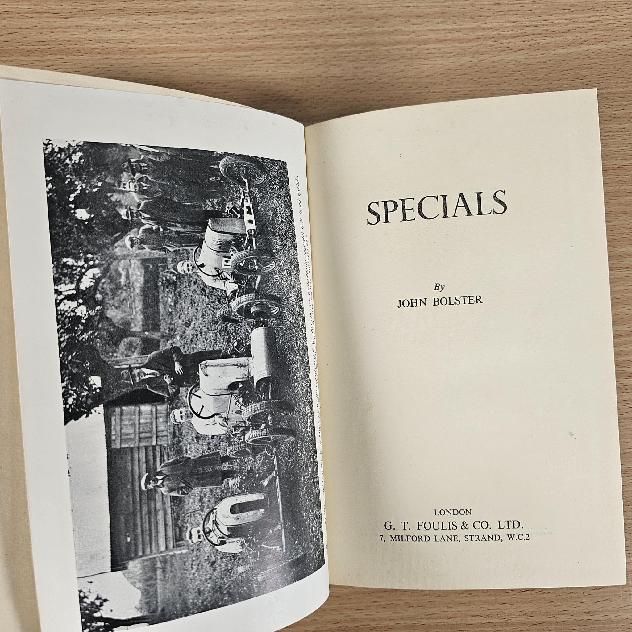 Open racing book spread with black photo page on the left and title page on the right