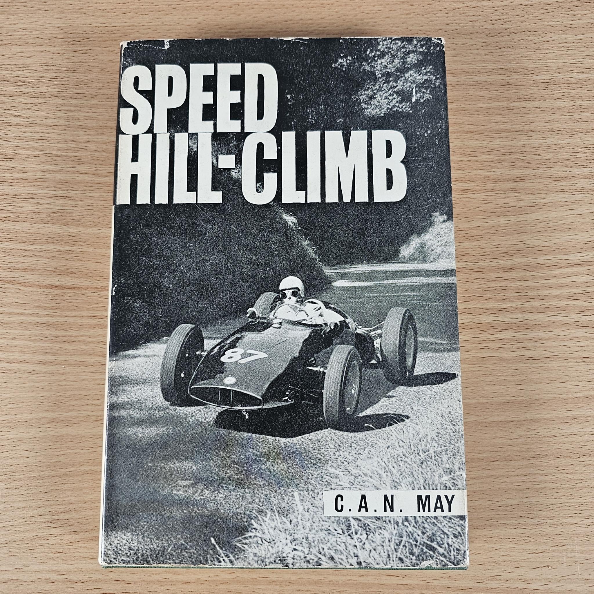 Vintage “Speed Hill-Climb” book cover with race car on track and “C.A.N. May” label