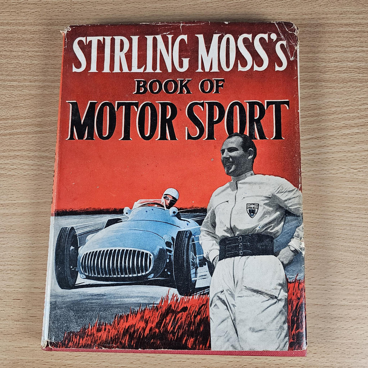 Vintage motor sport hardcover book, red front cover with Stirling Moss text and driver