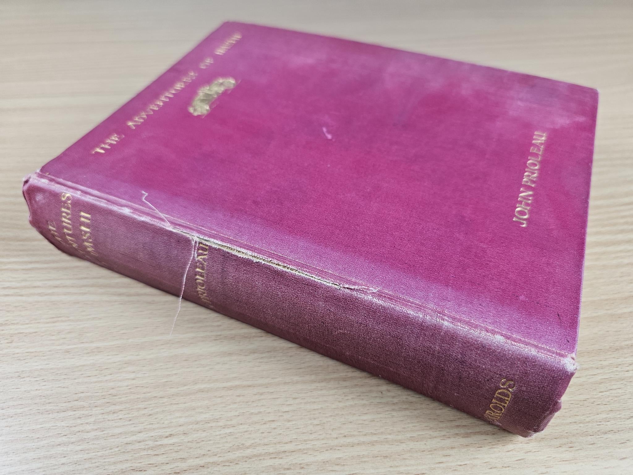 Maroon vintage hardcover book lying open at an angle, showing spine and cover edges