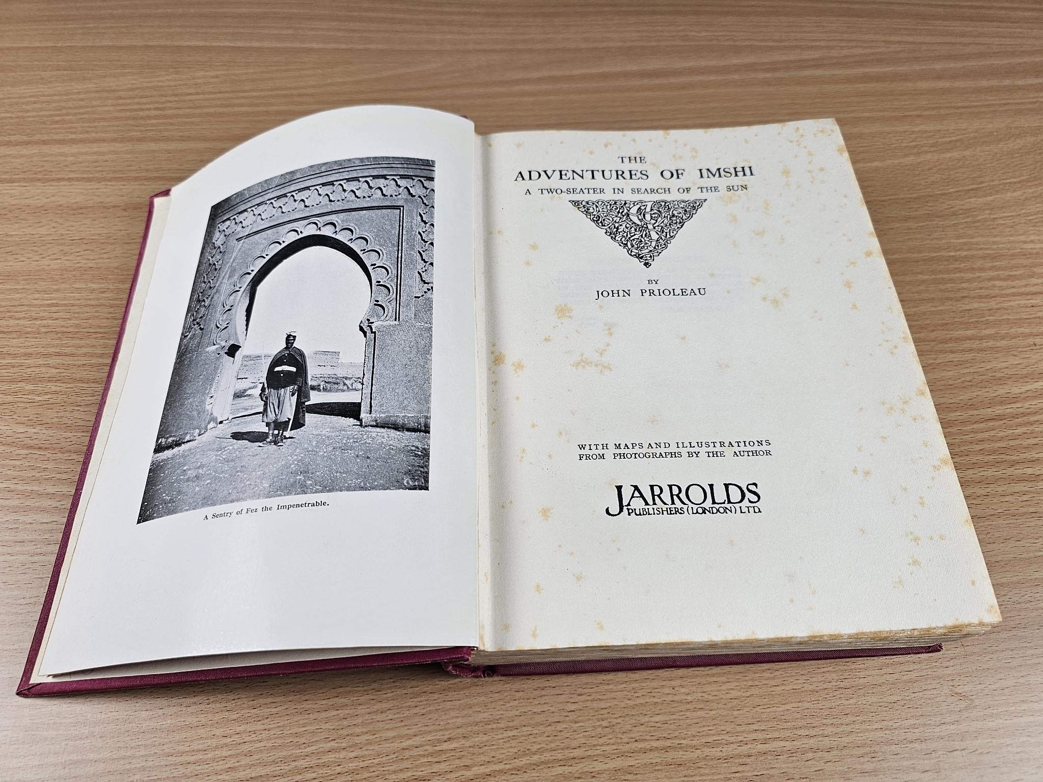 Opened vintage book with black-and-white photo plate and printed title page