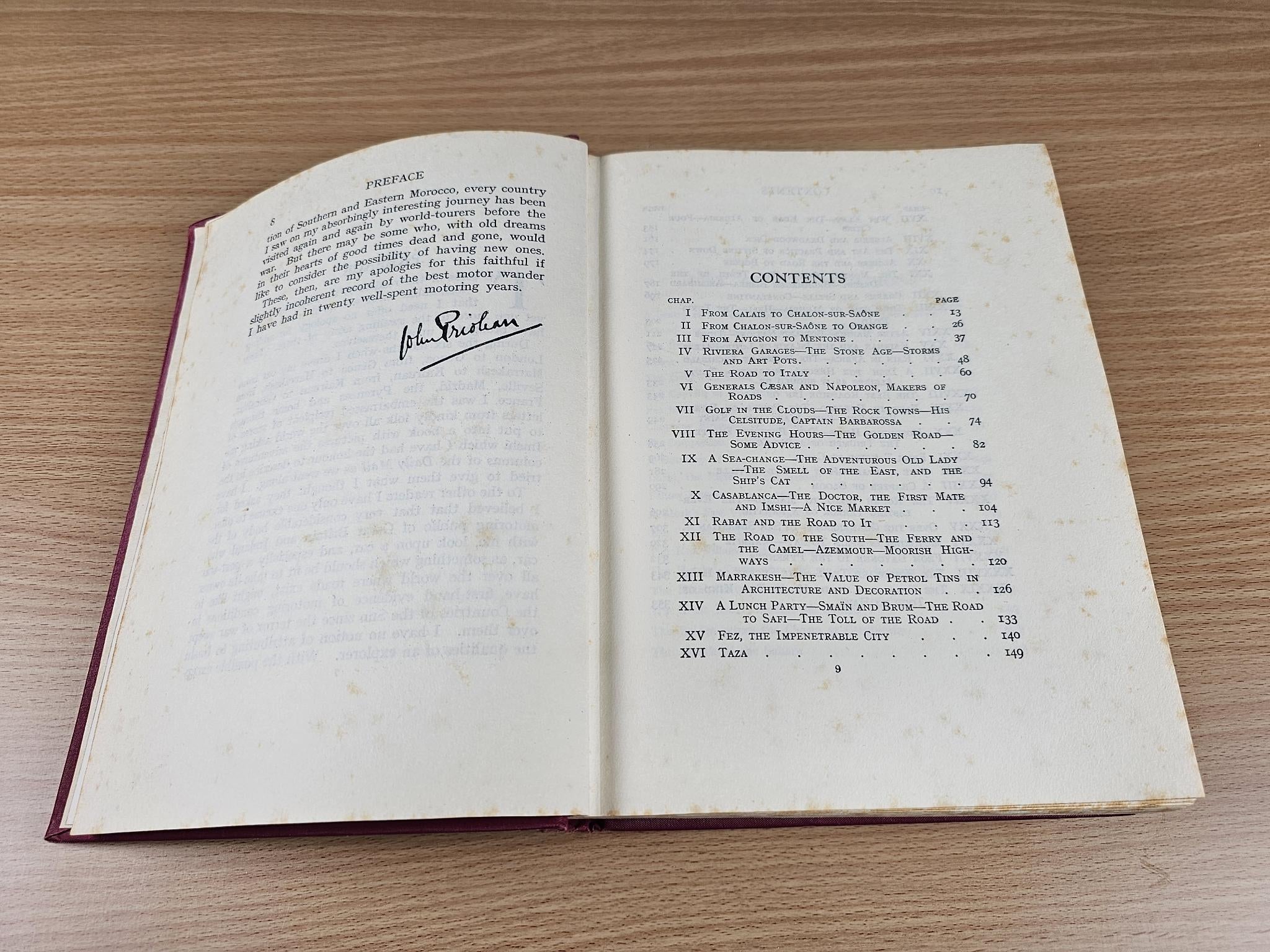 Opened vintage book showing signature on left page and contents list on the right