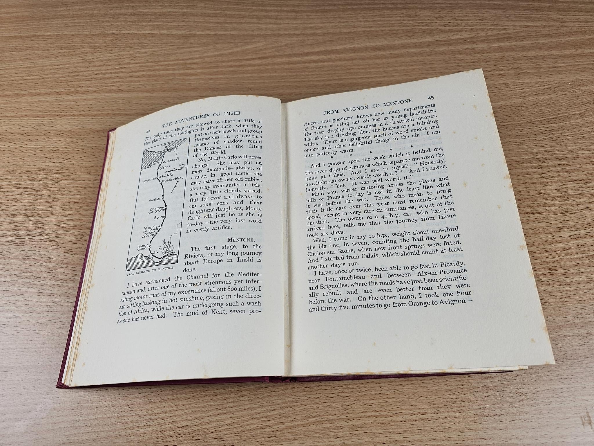 Opened vintage book with map diagram on left page and paragraphs on the right