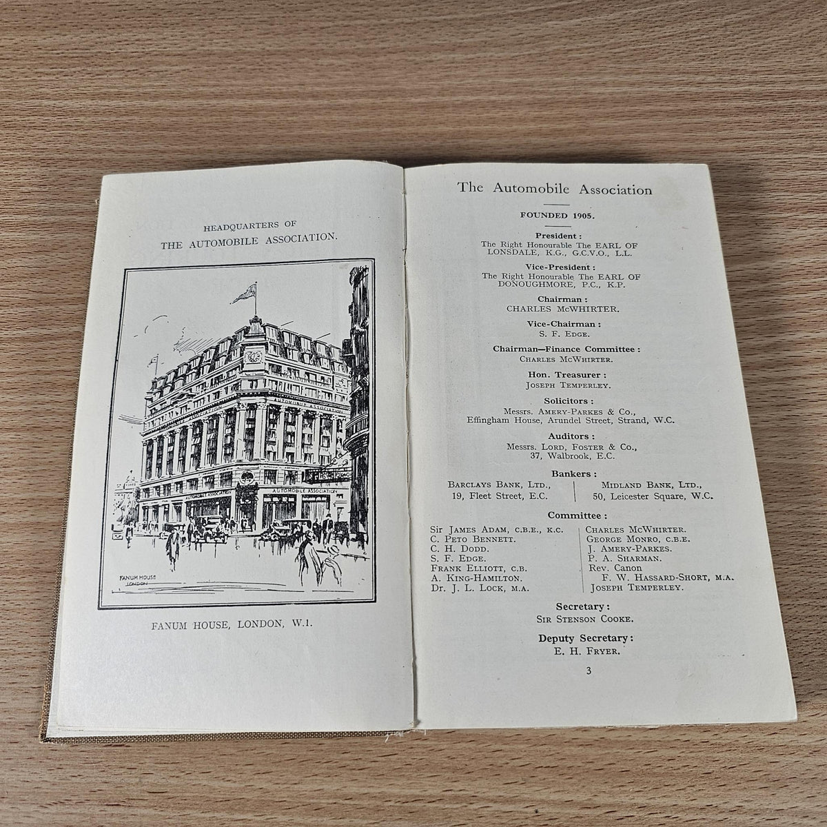 Open vintage AA foreign touring guide with illustrated building page and officials list