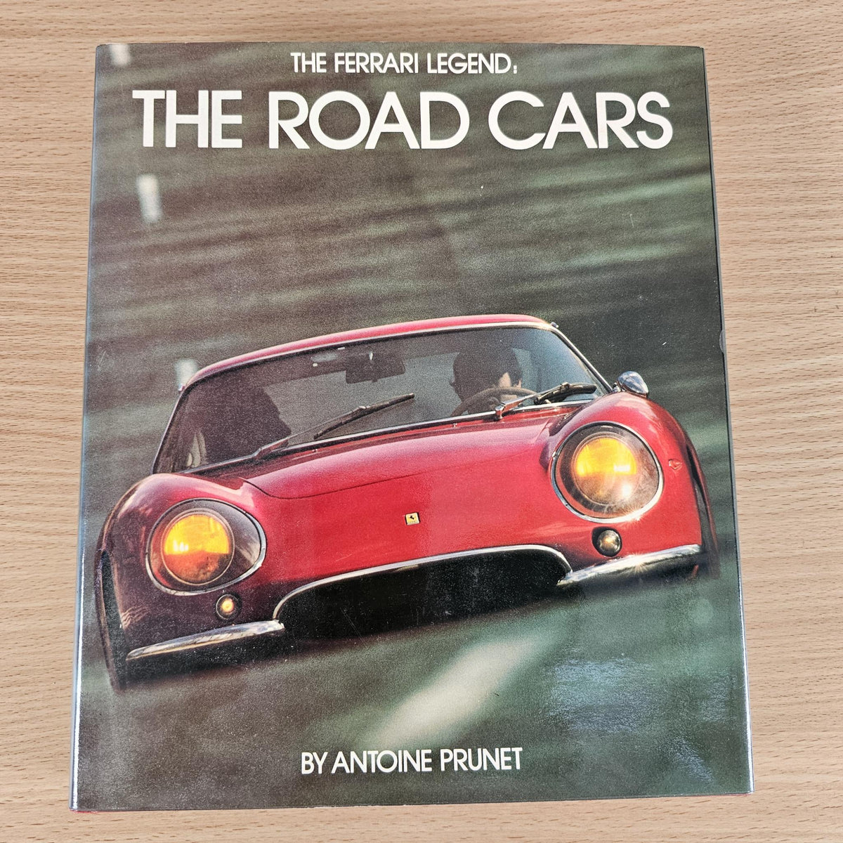 Ferrari book cover for The Road Cars with a red classic sports car front view