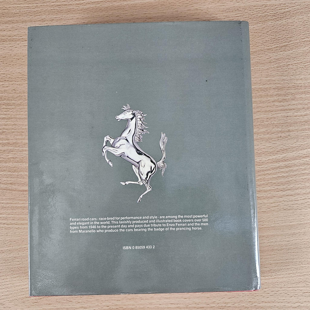 Ferrari book back cover with a white horse emblem and small printed details