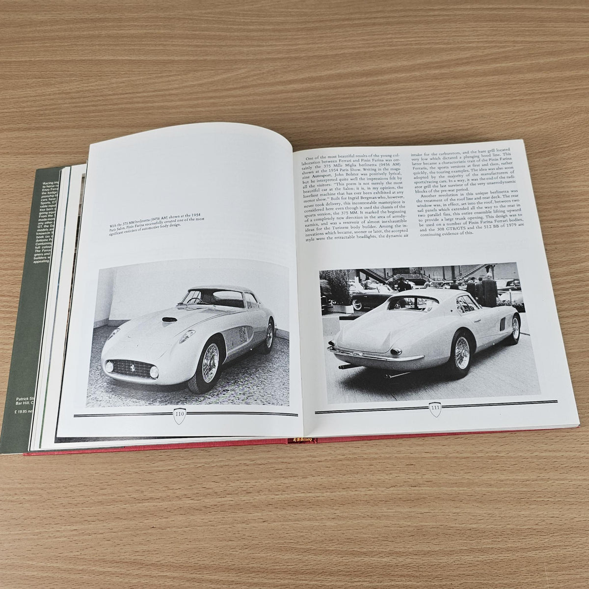 Open classic sports car photo book featuring white car image spread.