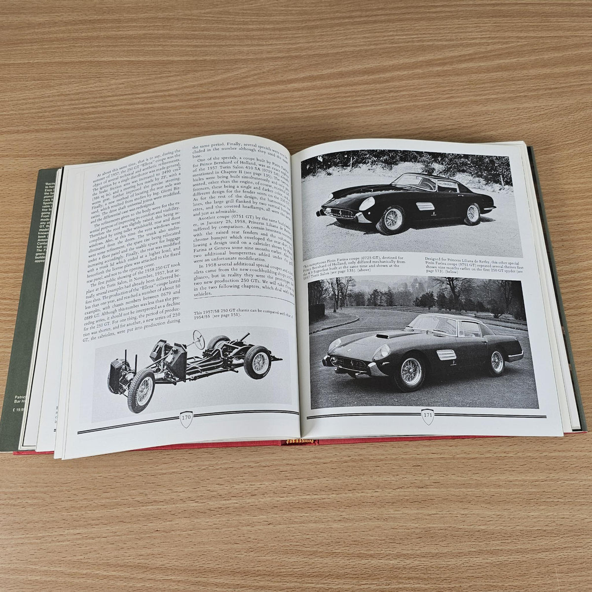 Open classic car photo book with black-and-white car images on both pages.
